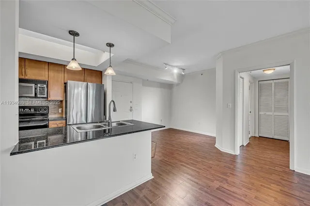 a kitchen with kitchen island a counter top space appliances and a ceiling fan