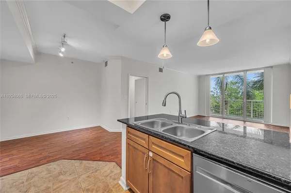 a kitchen with stainless steel appliances granite countertop a sink a window and a counter space