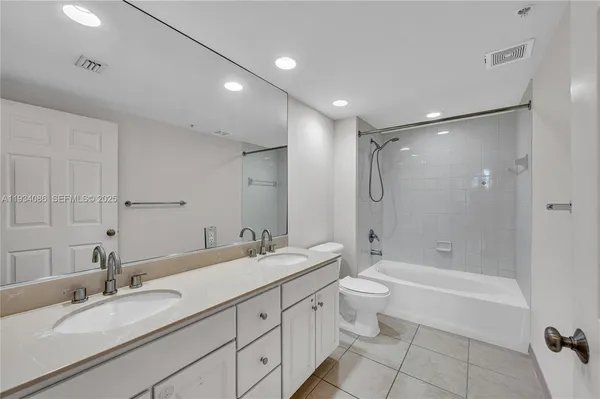 a bathroom with a double vanity sink toilet mirror and shower