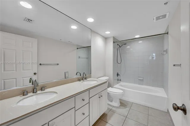 a bathroom with a double vanity sink toilet mirror and shower