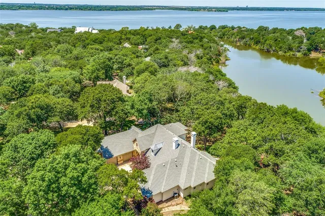 an aerial view of a house with a yard and lake view