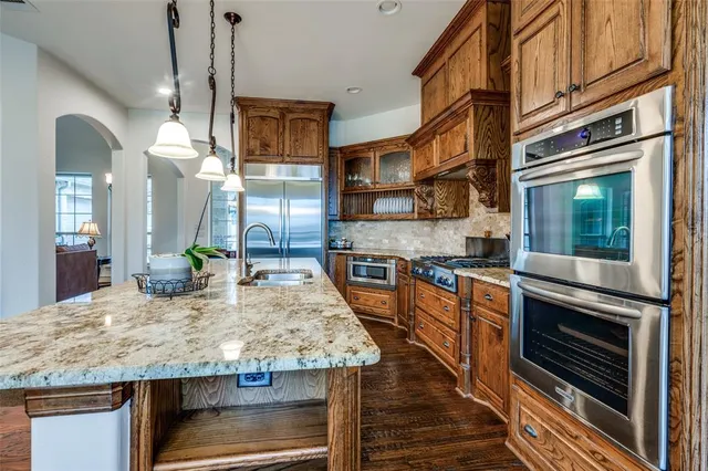 a kitchen with kitchen island granite countertop wooden cabinets and a stove