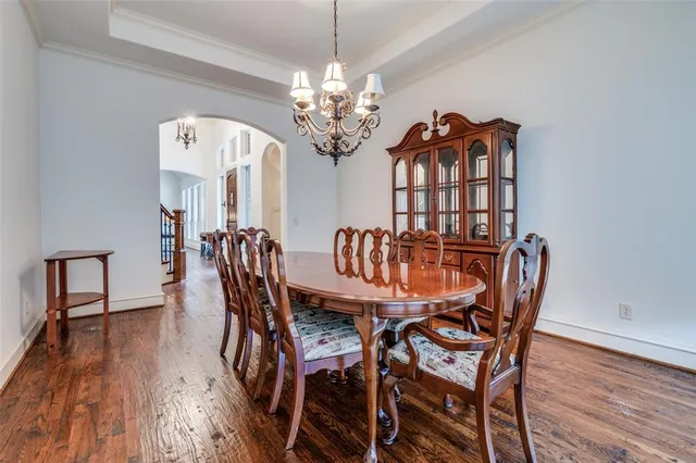 a view of a dining room with furniture a chandelier and wooden floor