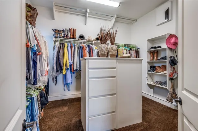 a view of walk in closet with clothes and shoes
