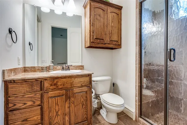 a bathroom with a granite countertop toilet sink and mirror