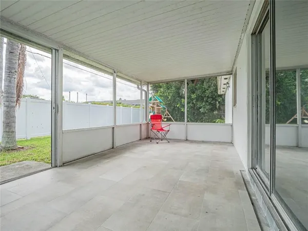 a view of an empty room with wooden floor and windows