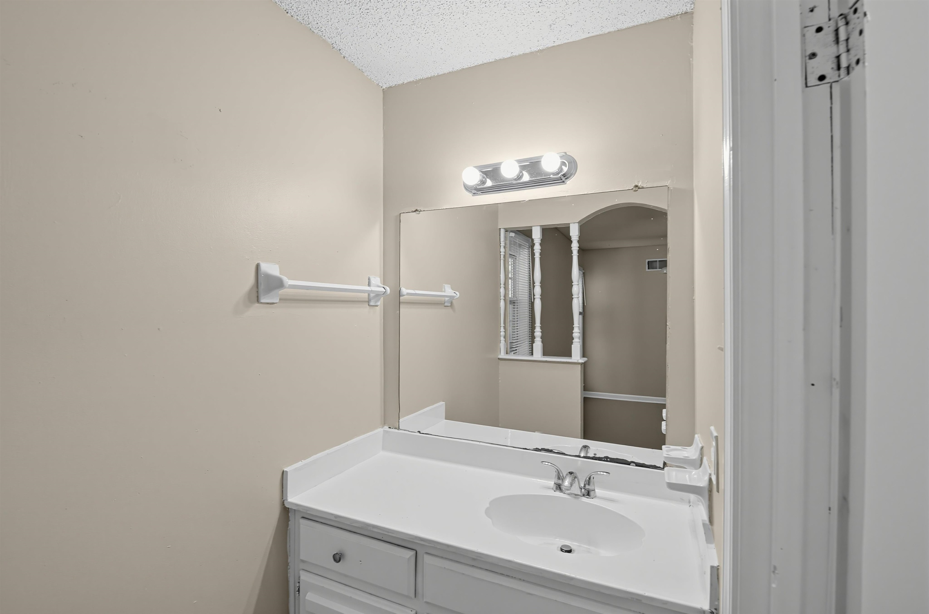 6350 Midsummer Way Memphis, TN 38115 - Photo 19 of 21 Vanity with an integrated white sink, chrome faucet, and a large wall-mounted mirror