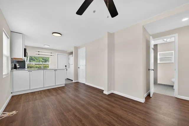 an empty room with ceiling fan and window