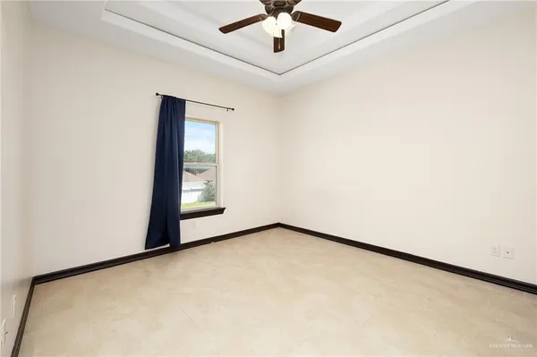 an empty room with windows and ceiling fan