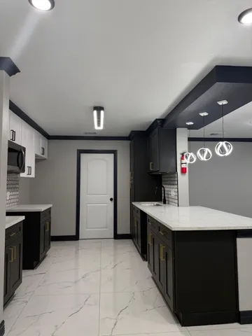 a large white kitchen with a sink and dishwasher a oven with wooden cabinets