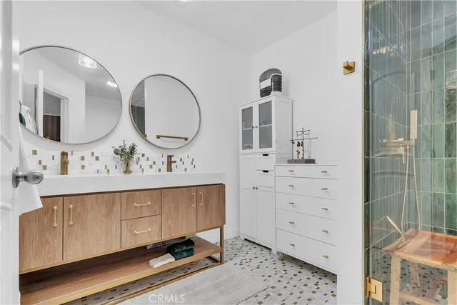 a bathroom with a double vanity sink mirror and shower