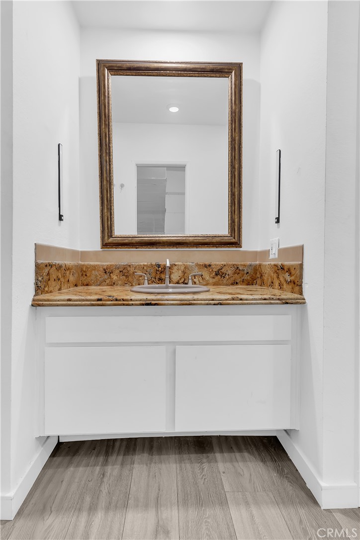 9005 Cynthia Street, Unit 317 West Hollywood, CA 90069 - Photo 16 of 23 a bathroom with a granite countertop sink and a mirror