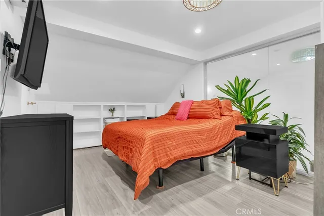 a bedroom with a bed and a potted plant