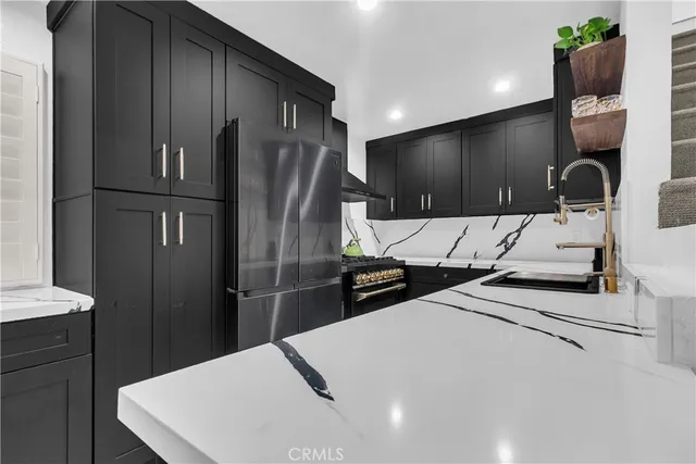 a kitchen with stainless steel appliances kitchen island a refrigerator sink and stove