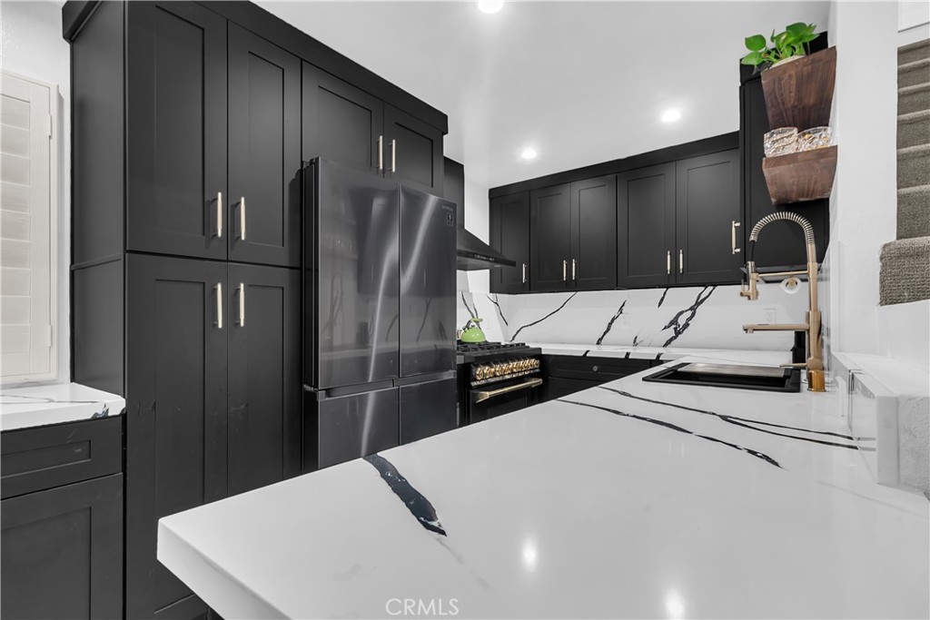 9005 Cynthia Street, Unit 317 West Hollywood, CA 90069 - Photo 4 of 23 a kitchen with stainless steel appliances kitchen island a refrigerator sink and stove