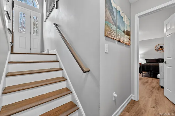 a view of a hallway with wooden floor and staircase
