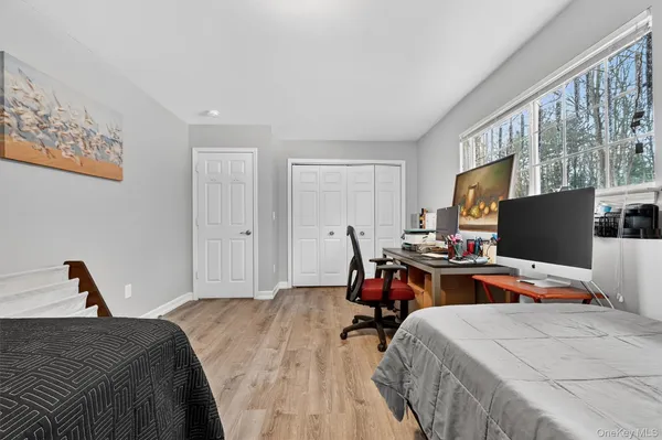 a bedroom with bed and a flat tv screen