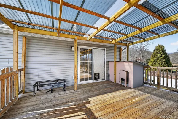 a view of a house with a barbeque and wooden stairs