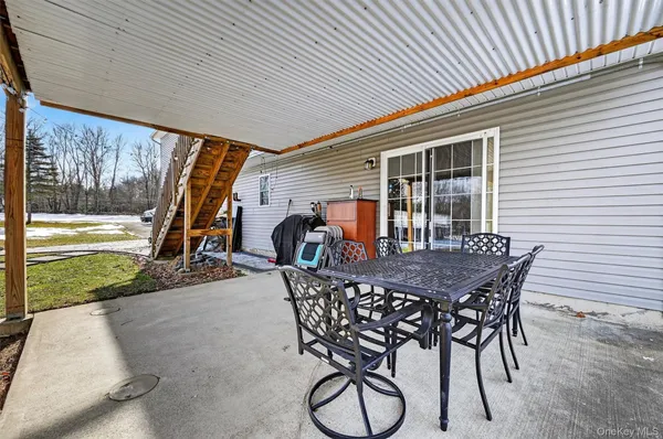 a view of a patio with table and chairs with wooden floor and fence
