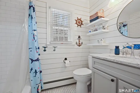 a bathroom with a sink a toilet and shower curtain