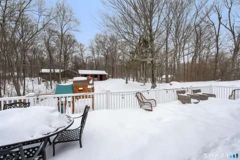 a view of backyard with sitting area and trees