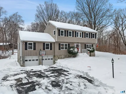 a front view of a house with a yard covered with snow