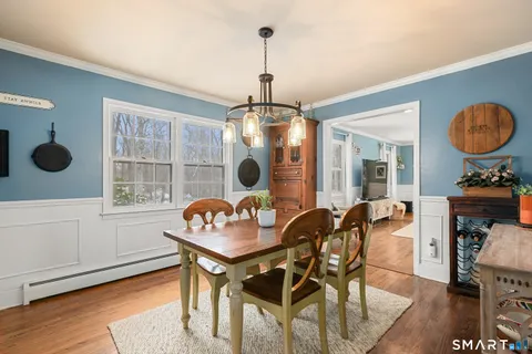 a dining room with furniture a chandelier and wooden floor