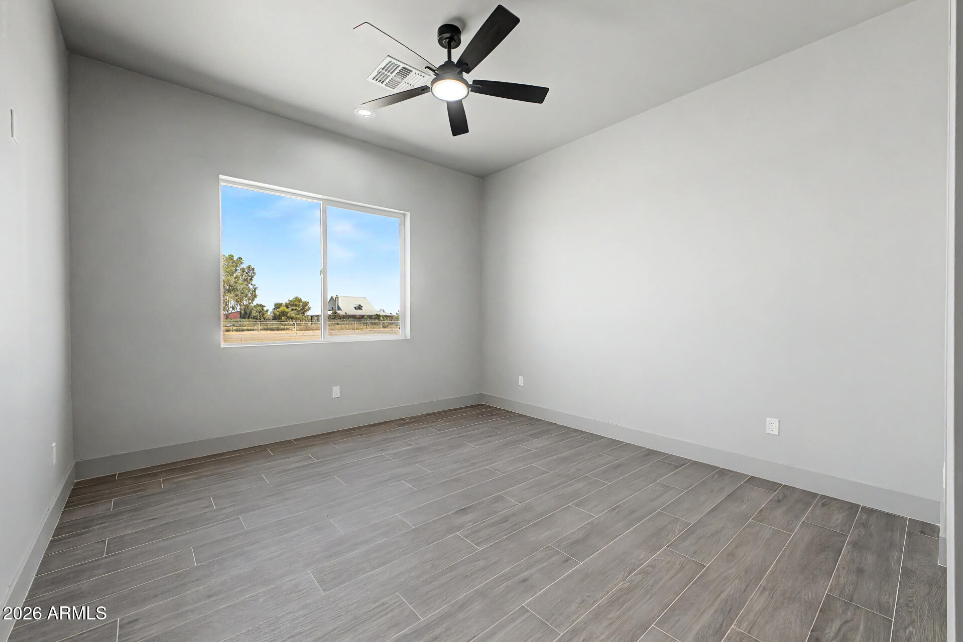 40461 West Robles Road Stanfield, AZ 85172 - Photo 43 of 54 an empty room with wooden floor ceiling fan and windows