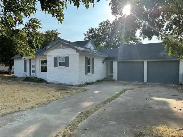 a view of a house with a yard and large tree
