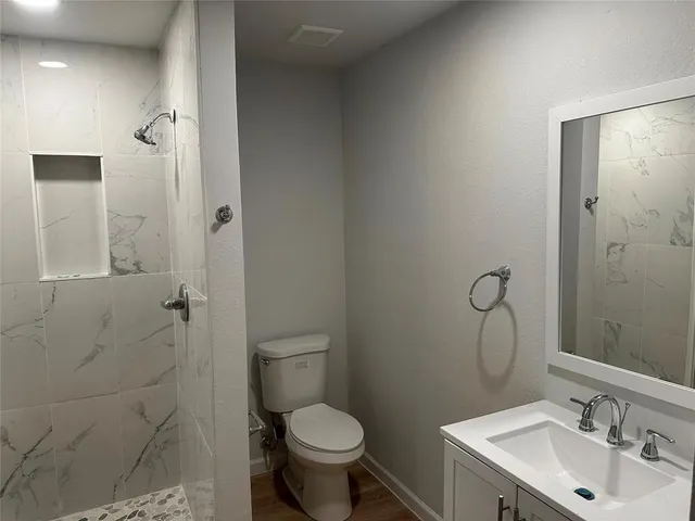 a bathroom with a sink toilet and shower