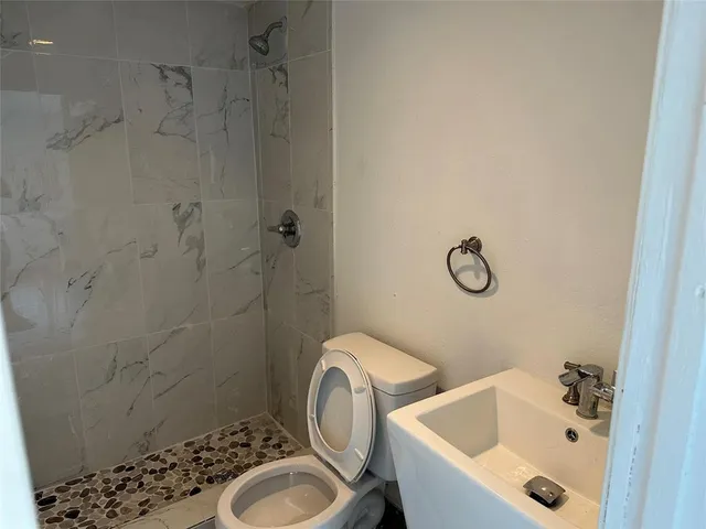 a bathroom with a sink toilet and shower