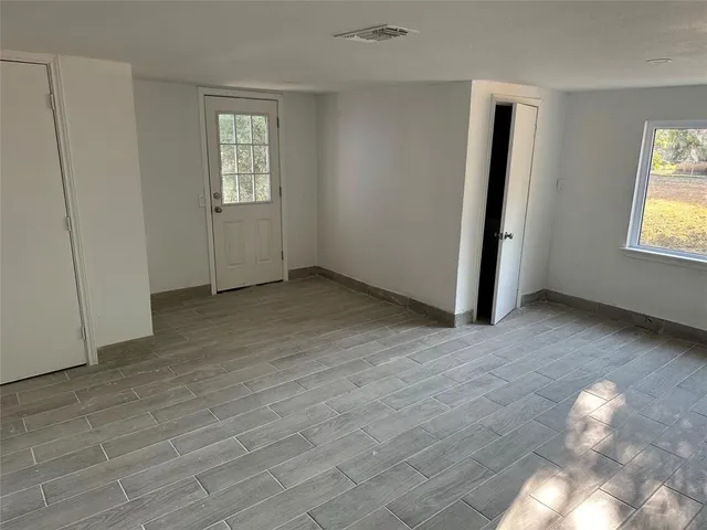 an empty room with windows and closet