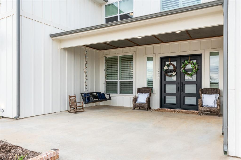 4600 Old Brock Road Weatherford, TX 76087 - Photo 4 of 37 Covered front porch featuring a board and batten facade, dual black entry doors with frosted glass panels, and recessed lighting