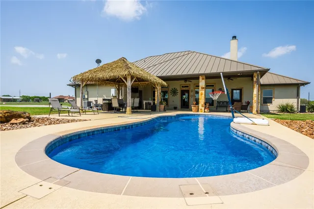 a view of a house with swimming pool and a yard