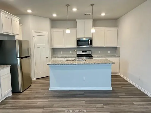 a view of kitchen with stainless steel appliances granite countertop a stove a refrigerator and a sink