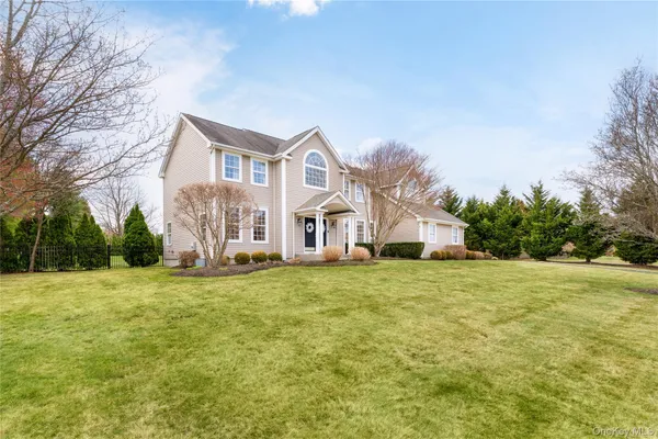 a front view of a house with a yard and trees