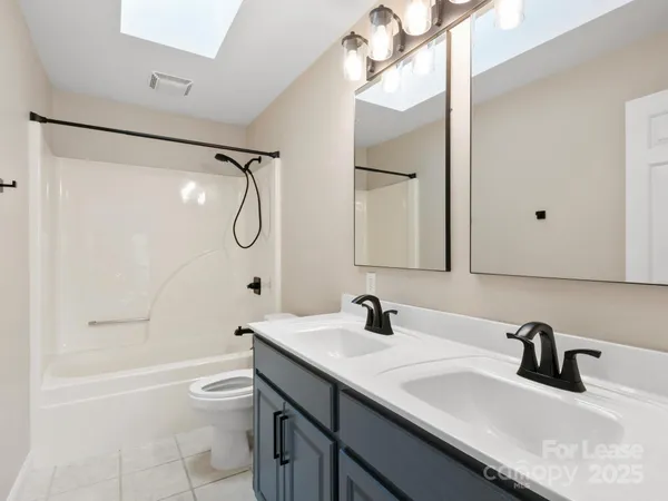 a bathroom with a granite countertop sink a toilet and shower