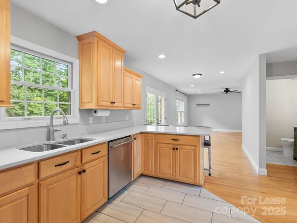 a large kitchen with stainless steel appliances granite countertop a sink and cabinets
