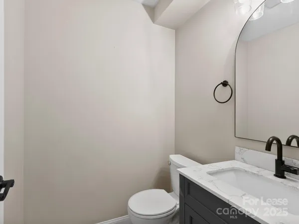 a bathroom with a granite countertop toilet sink and mirror