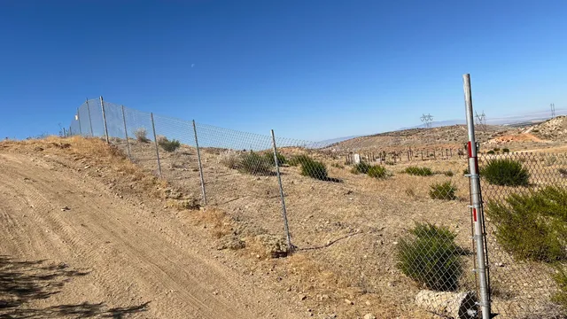 a view of a dry field with mountains in the background