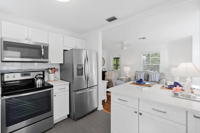 a kitchen with a sink stainless steel appliances and white cabinets