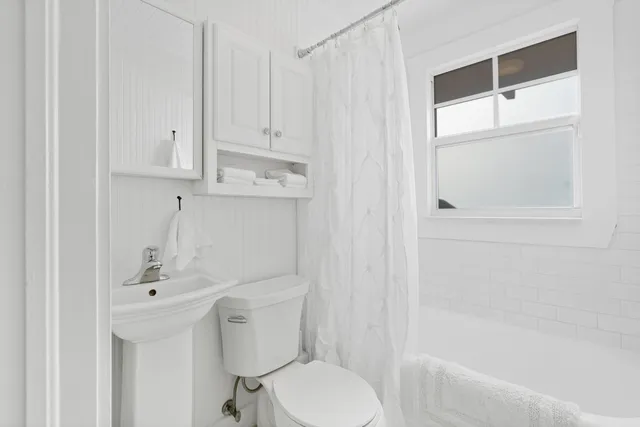 a bathroom with a sink a toilet and shower