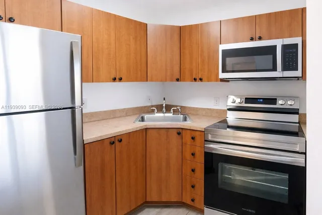 a kitchen with stainless steel appliances a stove microwave and refrigerator
