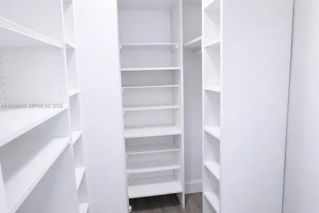 a view of walk in closet with empty racks