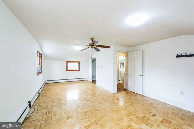 a view of a big room with windows and chandelier fan
