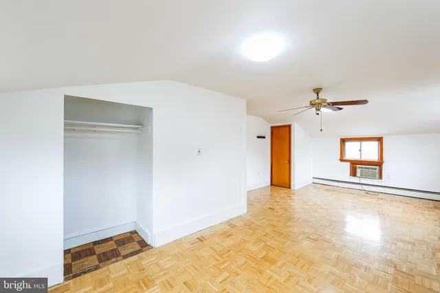 a view of a big room with windows and chandelier fan