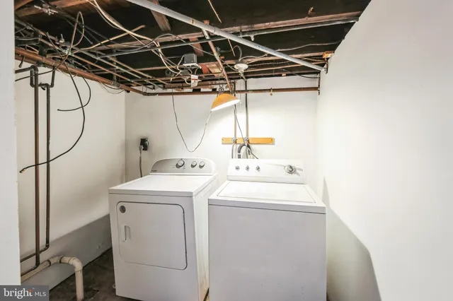 a view of an empty room with wooden floor and stairs