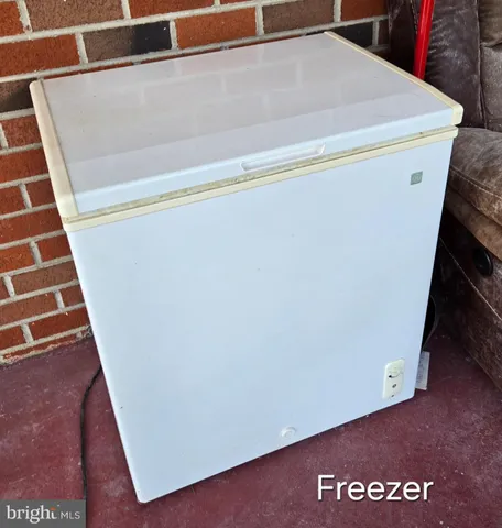 a view of a white house with a yard and potted plants