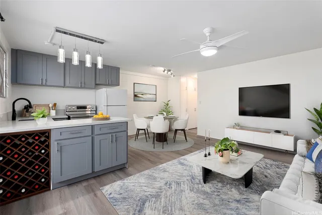 a living room with furniture kitchen view and a flat screen tv