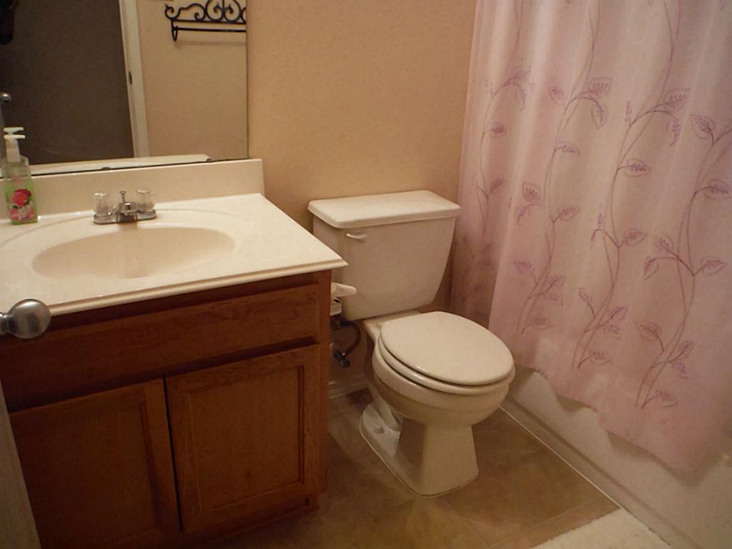 3142 Aspen Fair Trail Spring, TX 77389 - Photo 15 of 22 Cozy bathroom featuring a vanity with a sink, toilet, and a bath/shower combinations. Neutral tones create a warm, inviting atmosphere.